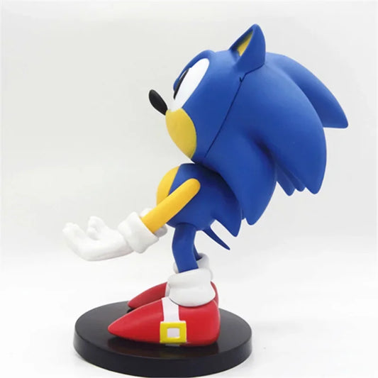 Figurine Sonic™ de profil en PVC sur socle noir, bras tendus pour support manette ou smartphone. Hauteur 18 cm, design rétro gaming SEGA.