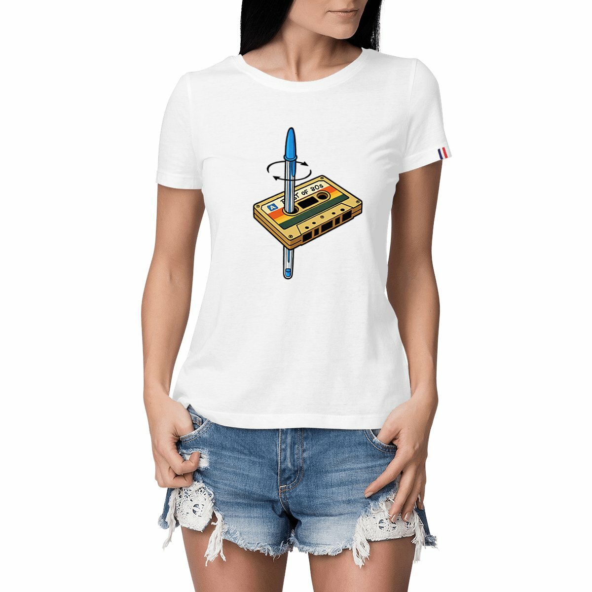 T-shirt blanc femme avec une illustration rétro d'une cassette audio des années 80 percée d’un stylo Bic bleu – visuel culte pour les nostalgiques, signé RÉTRONIC.