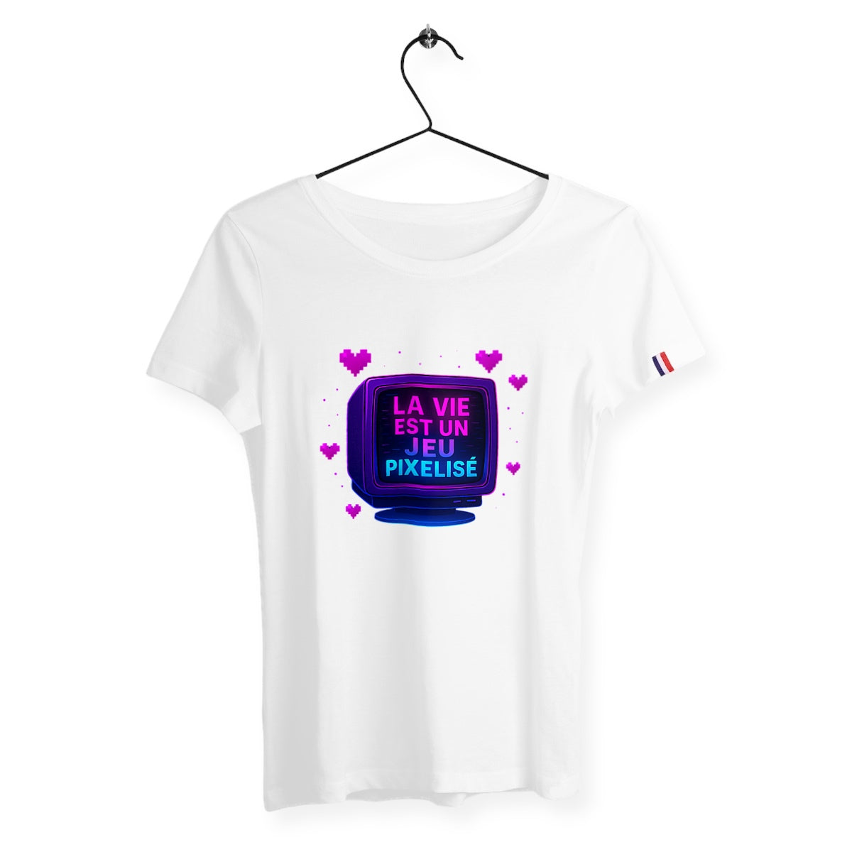 T-shirt femme blanc suspendu avec design rétro style pixel art représentant un écran CRT et l’inscription « LA VIE EST UN JEU PIXELISÉ » entouré de cœurs roses.