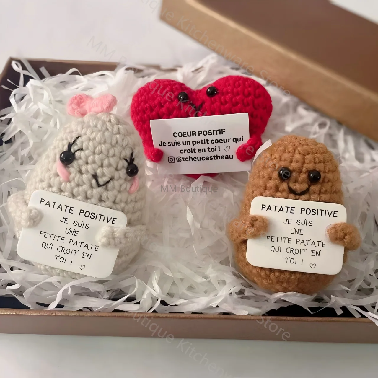 Coffret cadeau de peluches au crochet avec une Patate Positive blanche, un Cœur Positif rouge et une Patate Positive marron, présentées dans une boîte avec frisure.