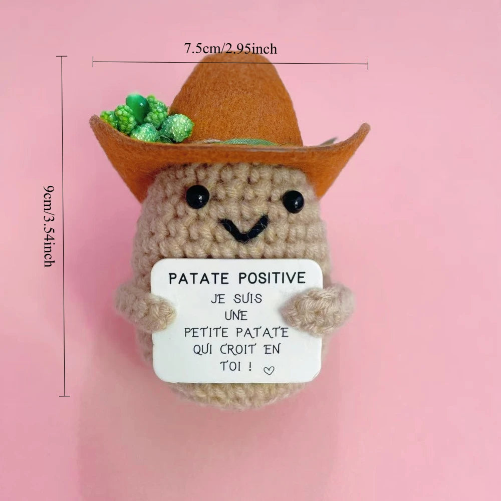 Peluche Patate Cowboy au crochet avec chapeau marron, tenant une pancarte “Je suis une petite patate qui croit en toi”, taille 9 cm.