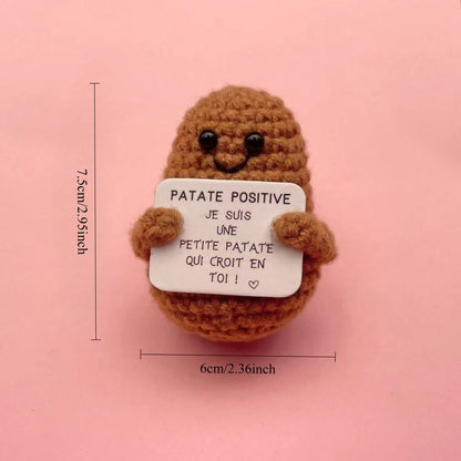 Peluche Patate Positive marron au crochet tenant une pancarte “Je suis une petite patate qui croit en toi”, format mini 7,5 cm.
