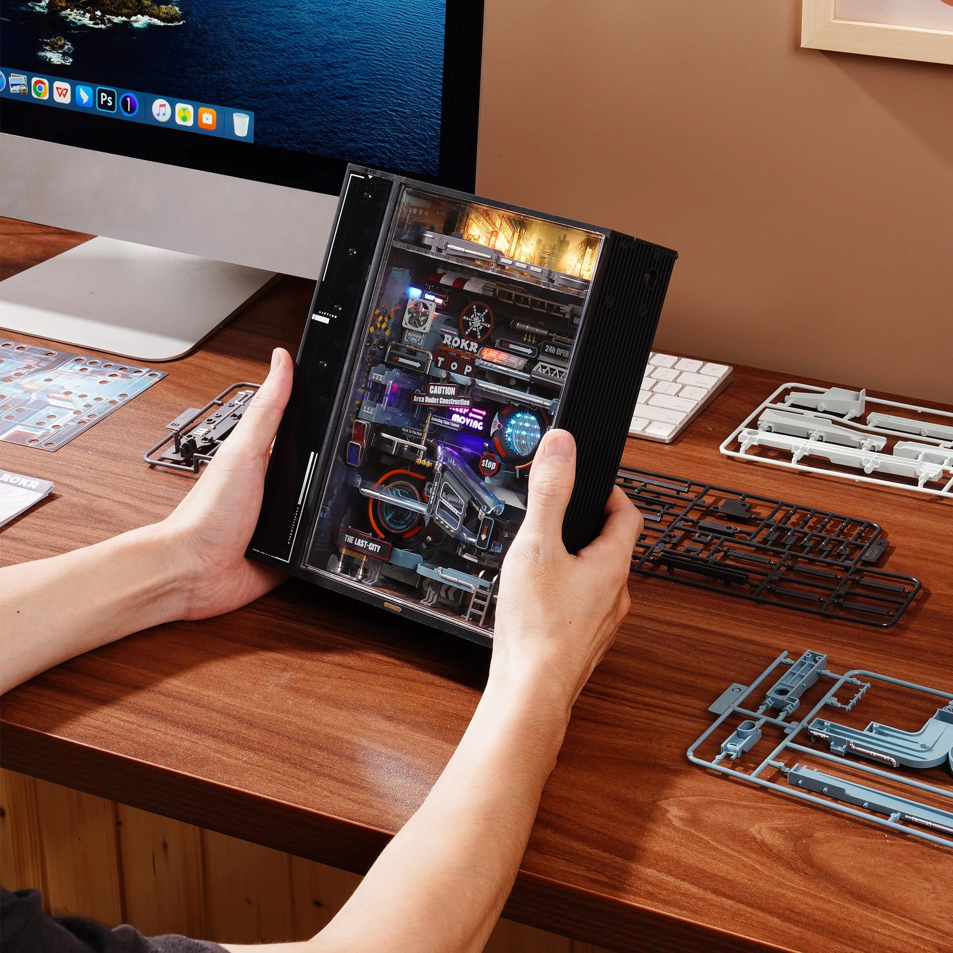 Maquette ROKR The Last City cyberpunk en cours de montage sur bureau, tenue en main – décoration gaming avec effet lumineux automatisé